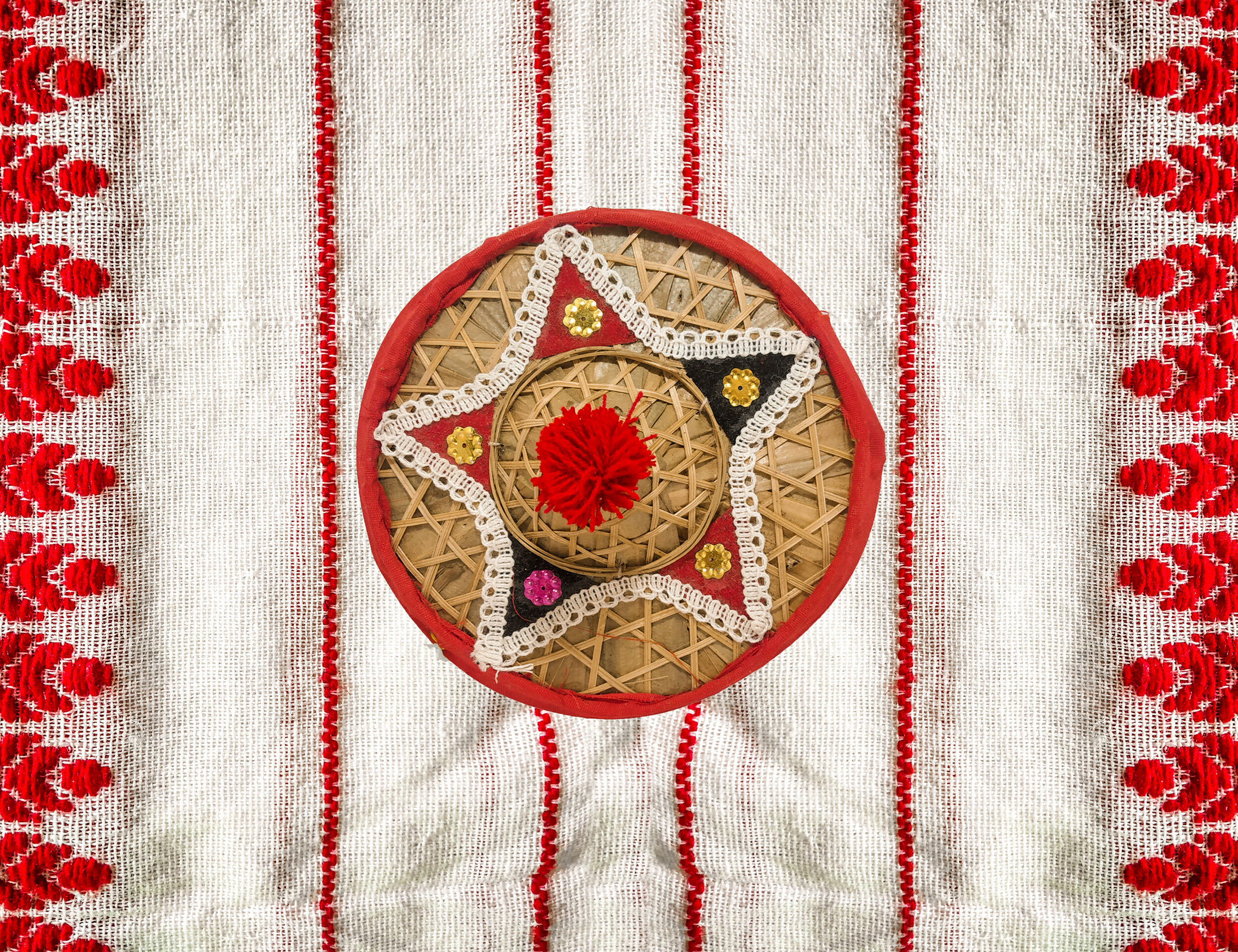 Traditional Assamese white fabric with colorful star-shaped patterns for Bohag Bihu