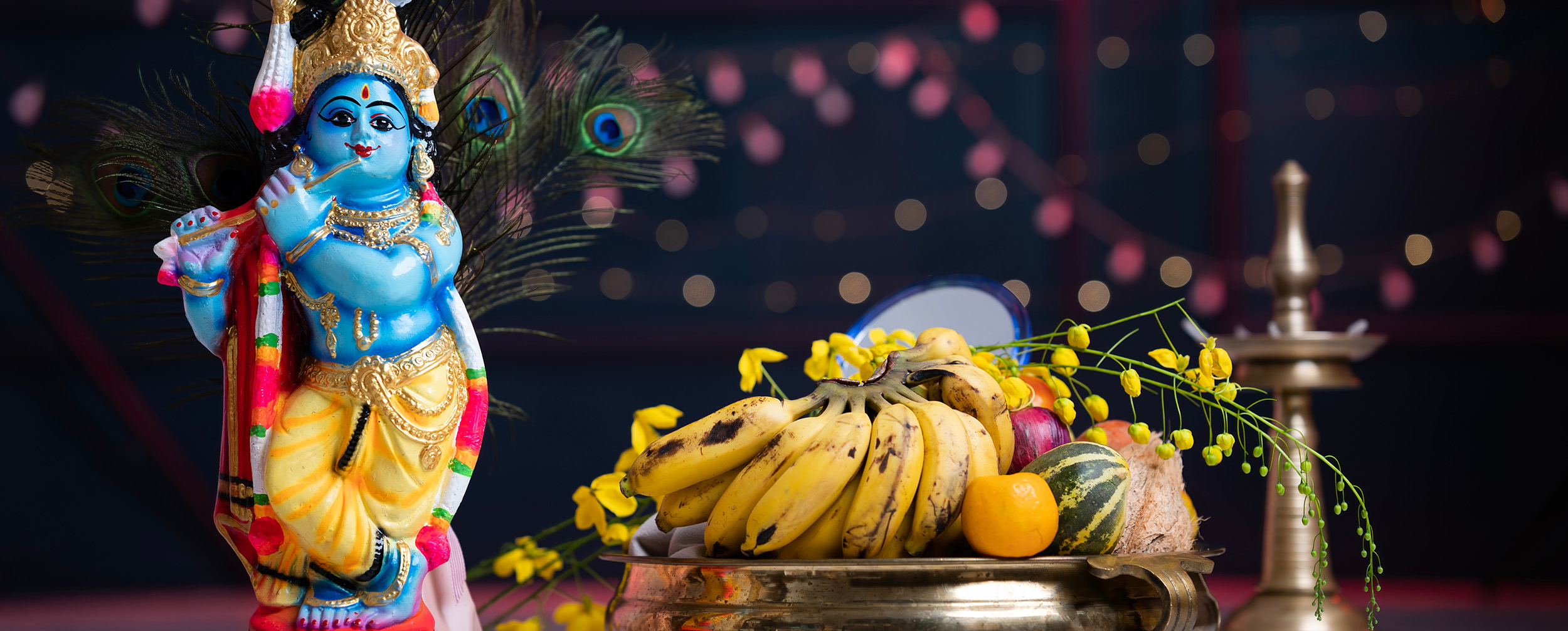 Colorful Krishna idol with peacock feathers, festive brass plate filled with bananas, fruits, and yellow flowers for Janmashtami celebration. Colorful Krishna idol with peacock feathers, festive brass plate filled with bananas, fruits, and yellow flowers for Janmashtami celebration.